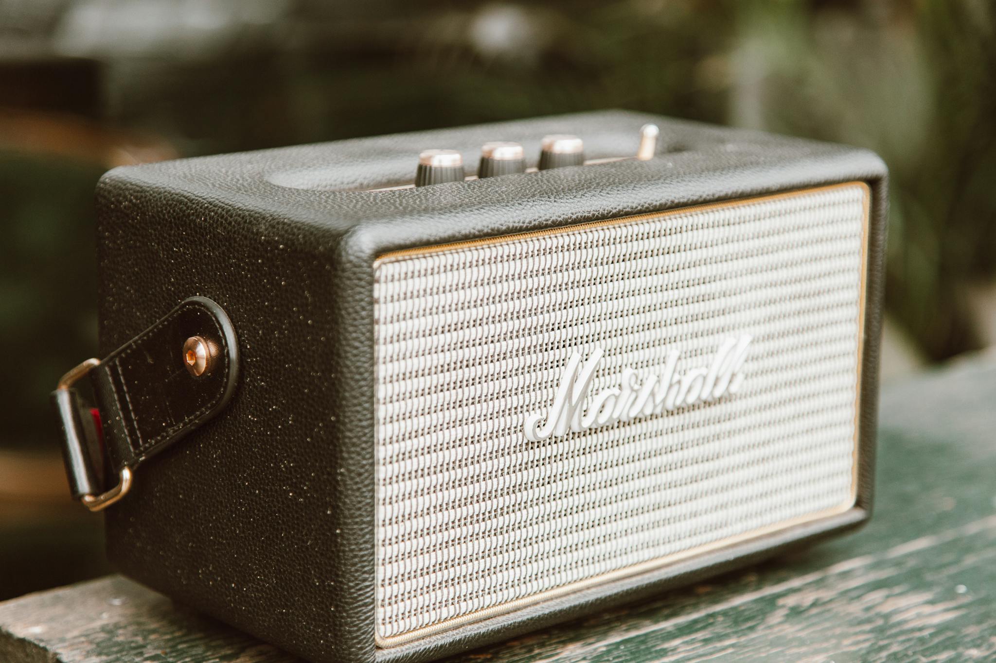 A stylish close-up shot of a vintage Marshall speaker amplifier with a leather strap.